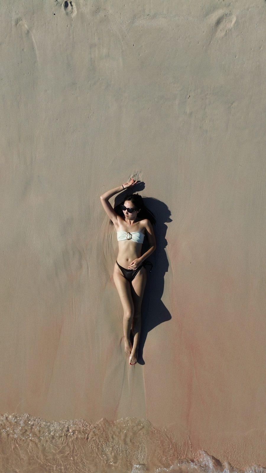 Swim Snorkel – woman lying on sand, aerial (Real photo from a KEXI trip)