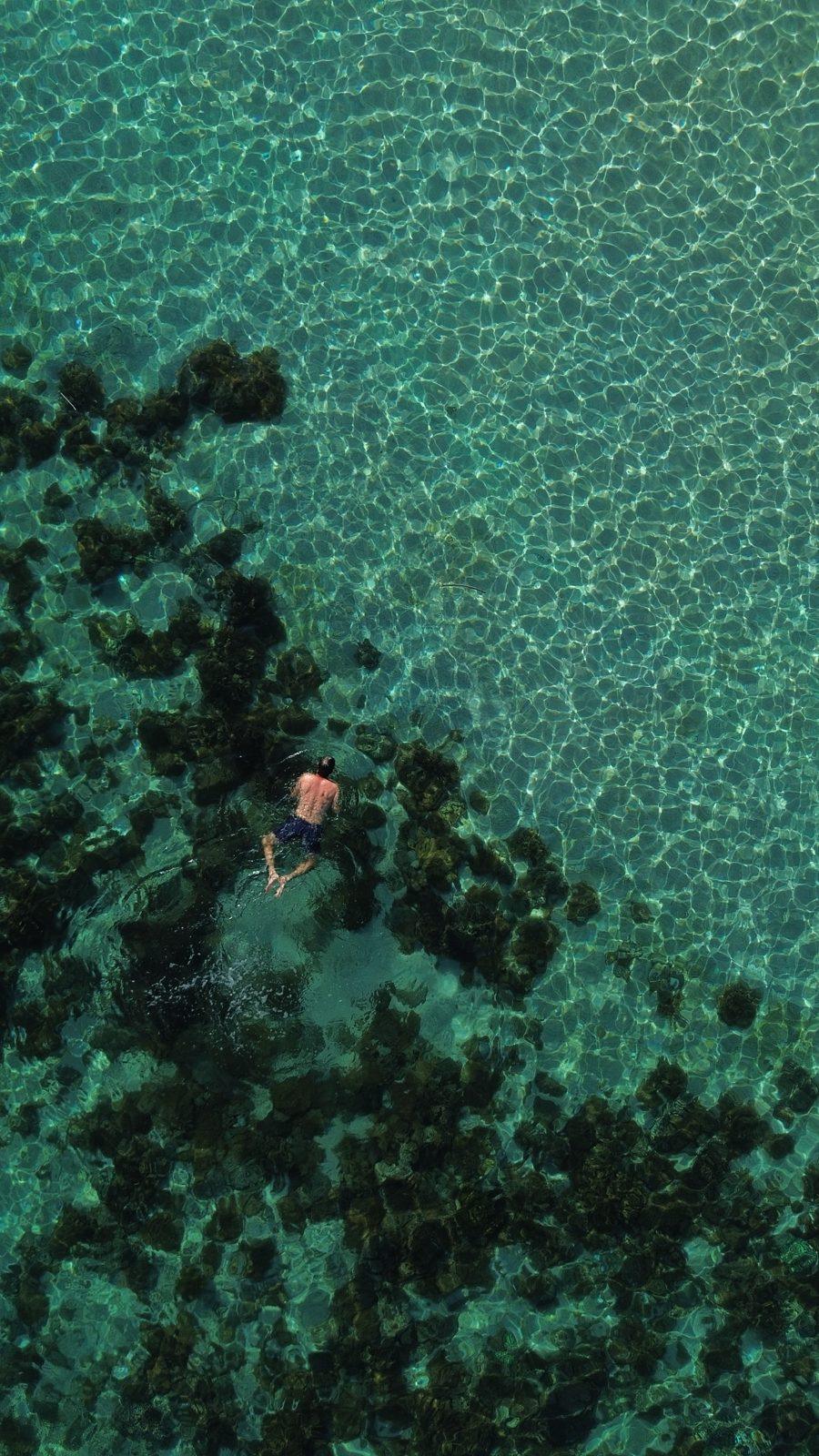 Swim Snorkel – aerial swimmer in turquoise water near reef (Real photo from a KEXI trip)