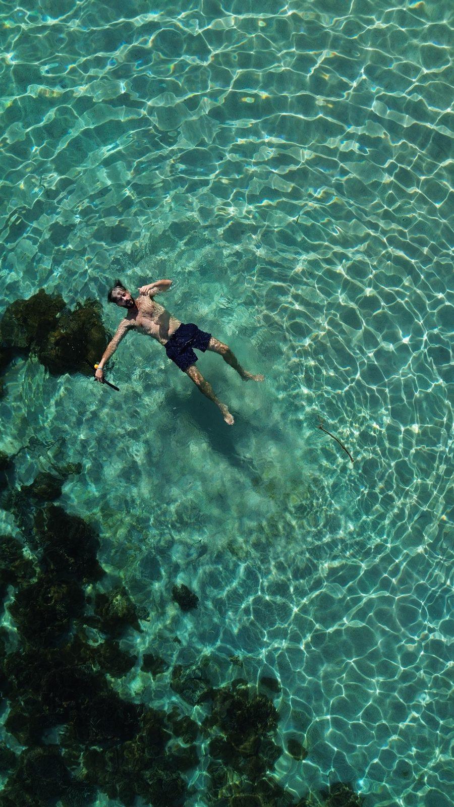 Swim Snorkel – aerial person floating in turquoise shallows (Real photo from a KEXI trip)